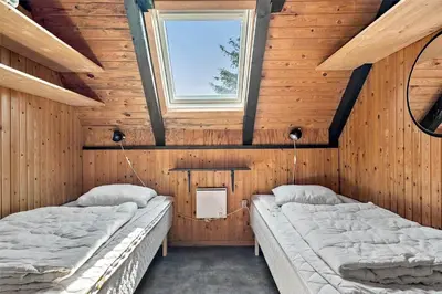 two beds in a room with wooden walls and a window at 465-Thisted-Havbovej-25 in Thisted