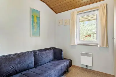 a blue couch in a room with a window at 560-Thisted-Klitrosevej-60 in Thisted