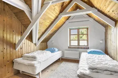 a attic room with two beds and a window at 707-Thisted-Lyngvej-12 in Thisted