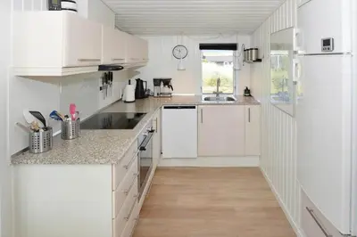 a white kitchen with white cabinets and a wooden floor at 1303-Thisted-Fiskervej-47 in Thisted