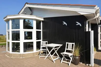 a patio with a table and chairs in front of a building at 1303-Thisted-Fiskervej-47 in Thisted