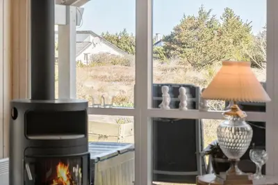 a fireplace in a living room with a window at 876-Thisted-Klemsvej-27 in Thisted
