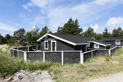 a black house on the side of a beach at 705-Thisted-Klitrosevej-22 in Thisted