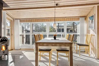 a dining room with a table and chairs and a fireplace at 705-Thisted-Klitrosevej-22 in Thisted