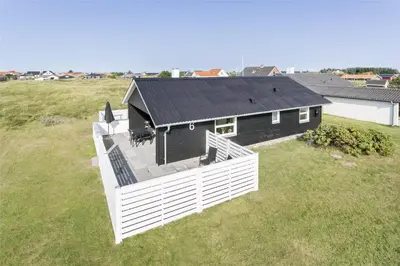 a house with a black roof on a grass field at 736-Thisted-Kuttervej-6 in Thisted