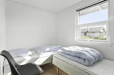 a bed in a room with a chair and a window at 736-Thisted-Kuttervej-6 in Thisted