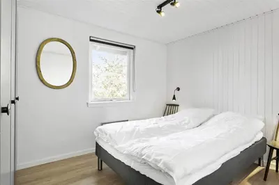 a white bedroom with a bed and a mirror at 736-Thisted-Kuttervej-6 in Thisted