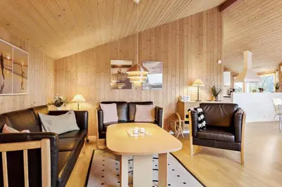a living room with leather chairs and a table at 990-Thisted-Spanggardsvej-29 in Torsted
