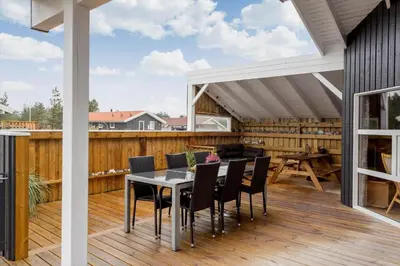 a patio with a table and chairs on a deck at 990-Thisted-Spanggardsvej-29 in Torsted
