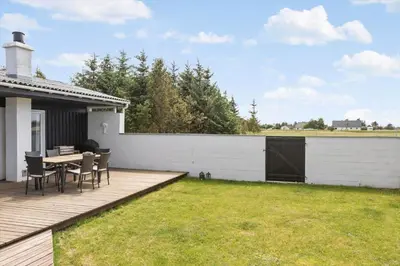 a backyard with a table and chairs on a deck at 518-Thisted-Klemsvej-18 in Thisted