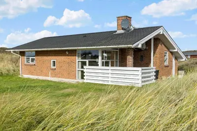 a small brick house on a grassy hill at 273-Snedsted-Sarasvej-33 in Snedsted