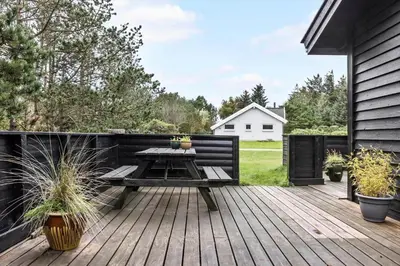 a wooden deck with a table and a bench at 912-Thisted-Astien-17 in Torsted