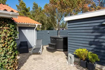 a patio with a chair and a trash can next to a fence at 704-Thisted-Kristinesvej-54 in Thisted