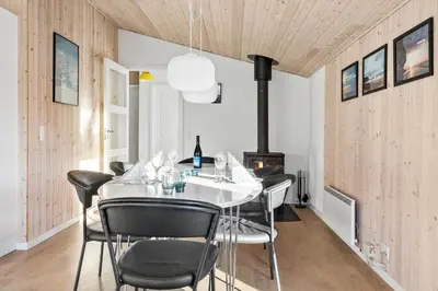 a dining room with a white table and black chairs at 475-Thisted-Muslingevej-5 in Thisted