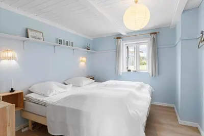 a white bed in a blue bedroom with a window at 492-Thisted-Tunvej-7-B in Thisted
