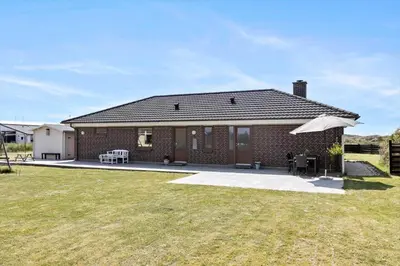 a brick house with a patio and an umbrella at 138-Thisted-Lervej-8-B in Thisted