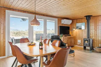 a dining room with a table and chairs and a television at 525-Vestervig-Spovevej-5 in Vestervig