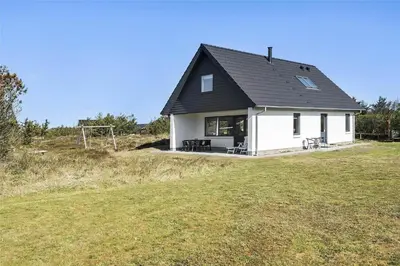 a white house with a black roof on a field at 803-Thisted-Hummervej-3 in Thisted
