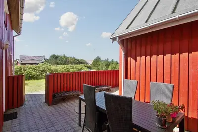 a patio with a table and chairs and a red building at 541-Thisted-Nordsovej-49 in Thisted