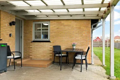 a patio with a table and chairs and a brick wall at 264-Vestervig-Krik-Strandvej-20 in Vestervig
