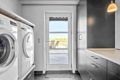 a laundry room with a washing machine and a window at 394-Vestervig-Magevej-43 in Vestervig