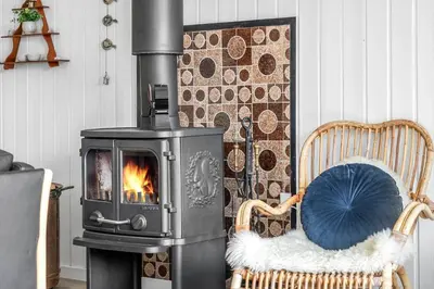 a wood stove in a living room with a chair at 620-Thisted-Pighvarvej-20 in Thisted