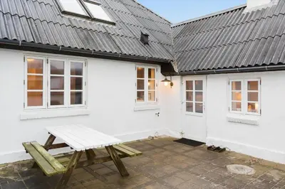 a white house with a bench in front of it at 893-Thisted-Vesterhavsgade-148 in Thisted