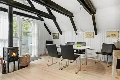 a dining room with a table and chairs and a fireplace at 621-Thisted-Molgaardsvej-21 in Thisted