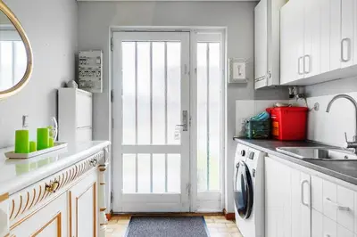 a kitchen with white cabinets and a door and a sink at 110-Vestervig-Svanholmvej-10 in Vestervig