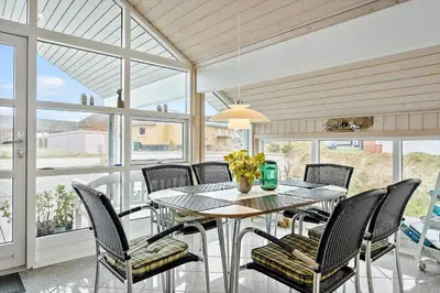a dining room with a table and chairs and windows at 362-Thisted-Ostersvej-1 in Thisted