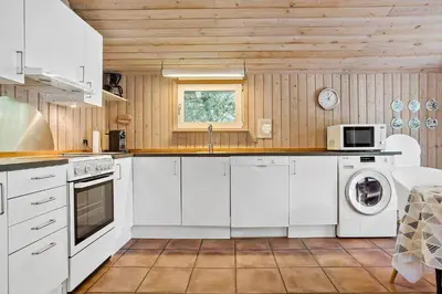 a kitchen with white cabinets and a washer and dryer at 466-Thisted-Muslingevej-6 in Thisted