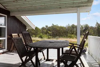 a wooden table and chairs on a porch with a table at 211-Vestervig-Rylevej-1 in Vestervig