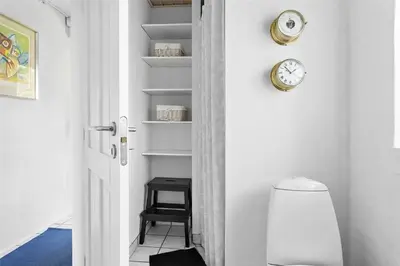 a door with a clock and a stool in a room at 643-Thisted-Bredkaervej-69-A in Thisted