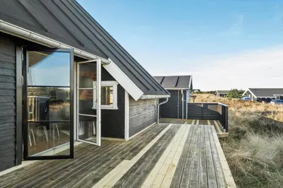 a home with a wooden deck next to a house at 718-Thisted-Orredvej-36 in Thisted