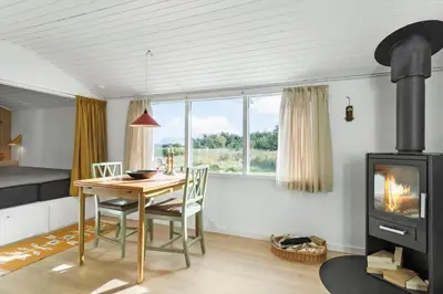 a dining room with a table and a wood stove at 114-Thisted-Tunvej-14 in Thisted