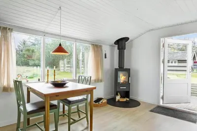 a dining room with a table and a wood stove at 114-Thisted-Tunvej-14 in Thisted