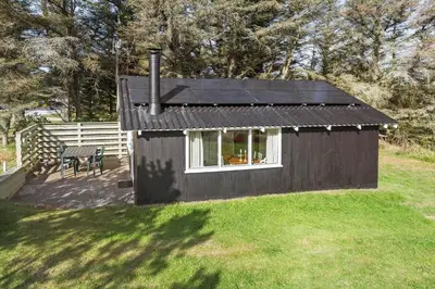 a small black house in a yard with a table at 114-Thisted-Tunvej-14 in Thisted