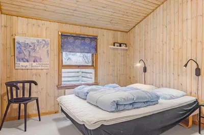 a bed in a room with a wooden wall at 318-Thisted-Nordsovej-204-A in Thisted