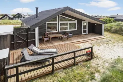 a small house with a deck with a table and chairs at 305-Thisted-Fiskervej-35 in Thisted