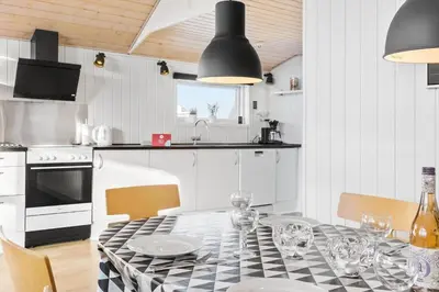 a kitchen with a table with plates and wine glasses at 305-Thisted-Fiskervej-35 in Thisted