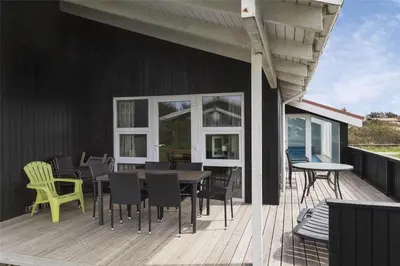 a deck with chairs and tables on a house at 970-Thisted-Klitstien-47 in Torsted