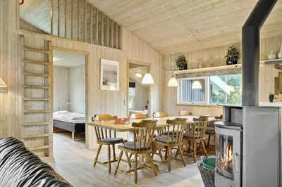 a kitchen and dining room with a table and a fireplace at 970-Thisted-Klitstien-47 in Torsted