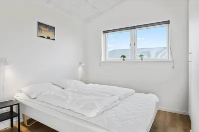 a white bedroom with a large bed with a window at 105-Thisted-Gronkaervej-19-B in Thisted