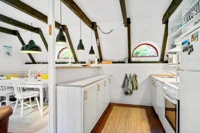 a kitchen with white cabinets and a dining table at 216-Snedsted-Grahavrevej-6 in Snedsted