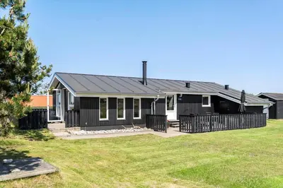 a black house with a fence in a yard at 534-Thisted-Fiskervej-123 in Thisted