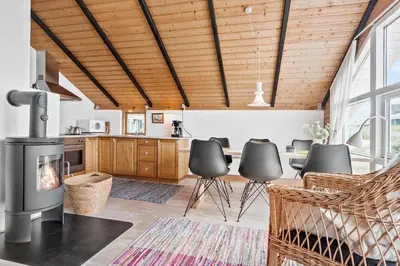 a living room with a fireplace and a table and chairs at 314-Thisted-Mose-Bollevej-14 in Thisted