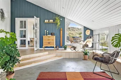 a living room with blue walls and stairs and a chair at 962-Thisted-Bavnbak-27 in Torsted