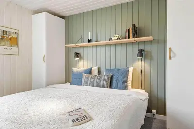a bedroom with a white bed with blue pillows at 962-Thisted-Bavnbak-27 in Torsted