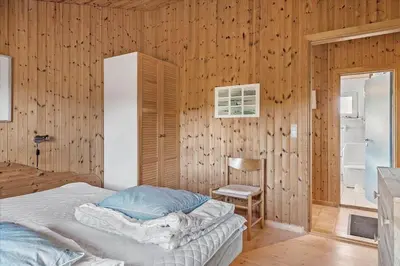 a bedroom with a bed and a wooden wall at 767-Thisted-Nordsovej-63 in Thisted