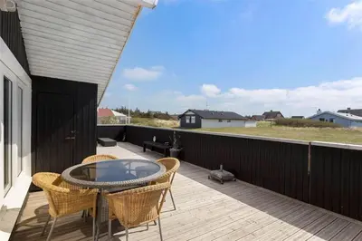 a patio with a table and chairs on a deck at 662-Thisted-Havbovej-18 in Thisted